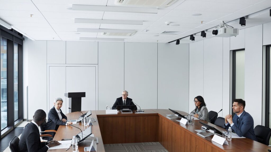 Legal Strategies That Protect Companies in International Business Disputes Delegates seated around a U-shaped conference table in a modern meeting room, illustrating legal Strategies That Protect Companies in International Business Disputes